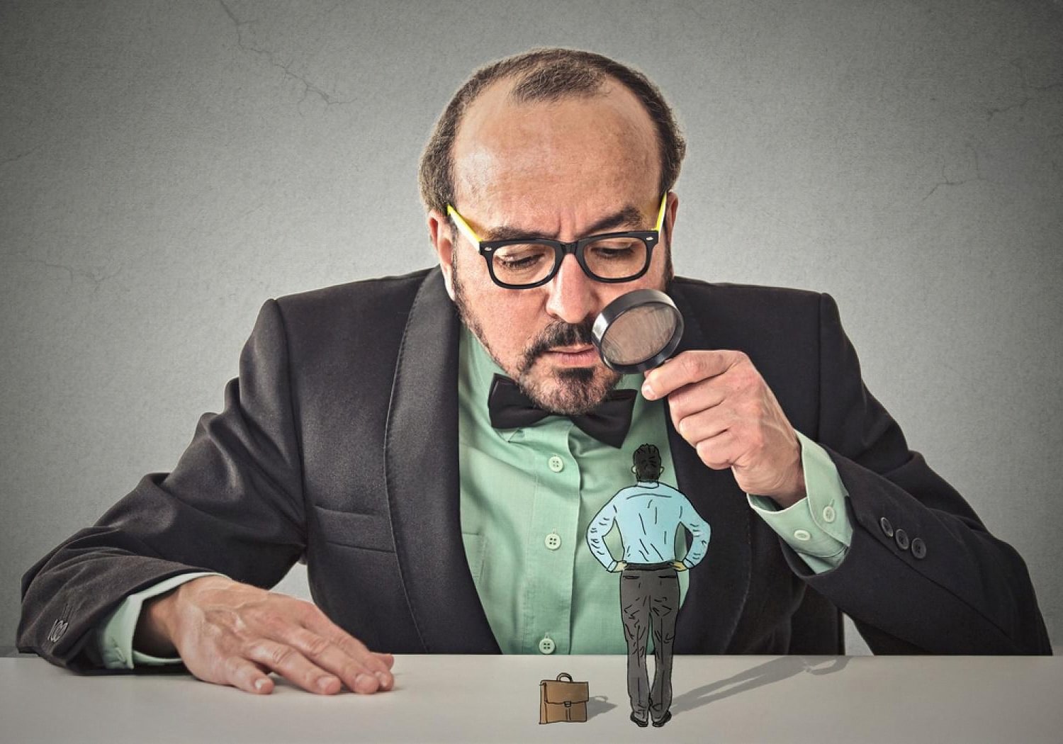 Recruiter examining a job candidate with a magnifying glass, representing executive background checks in the UAE