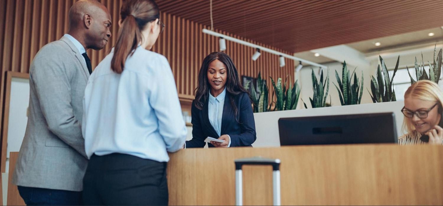 Hotel front desk staff checking in guests using a property management system